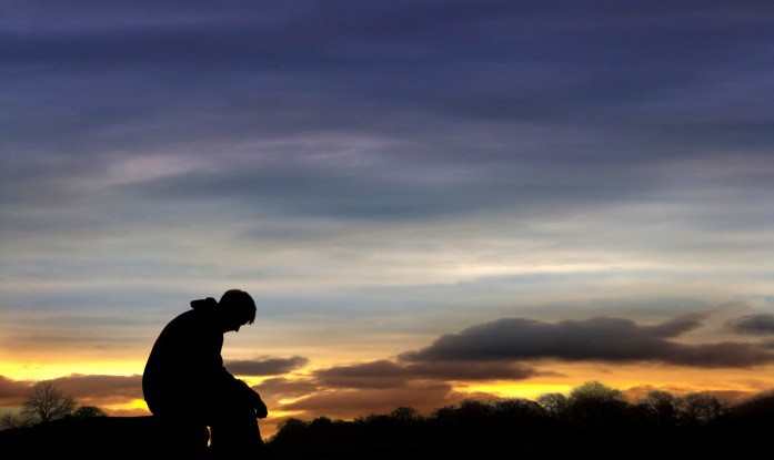 Sad man sitting in sunset