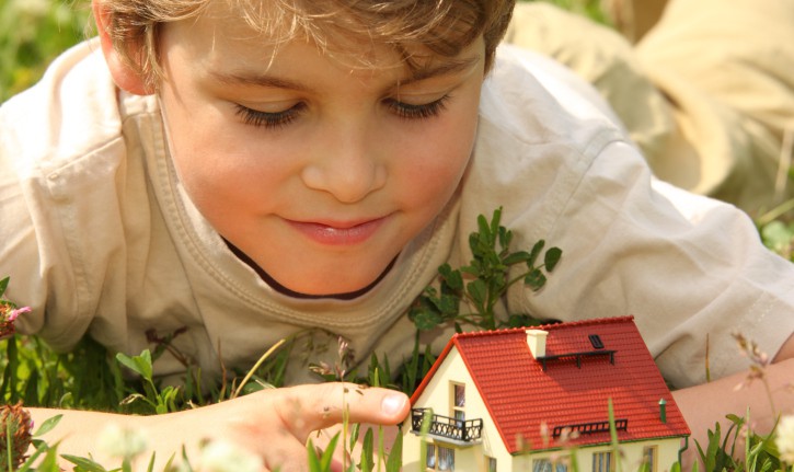 Boy and house model in grass